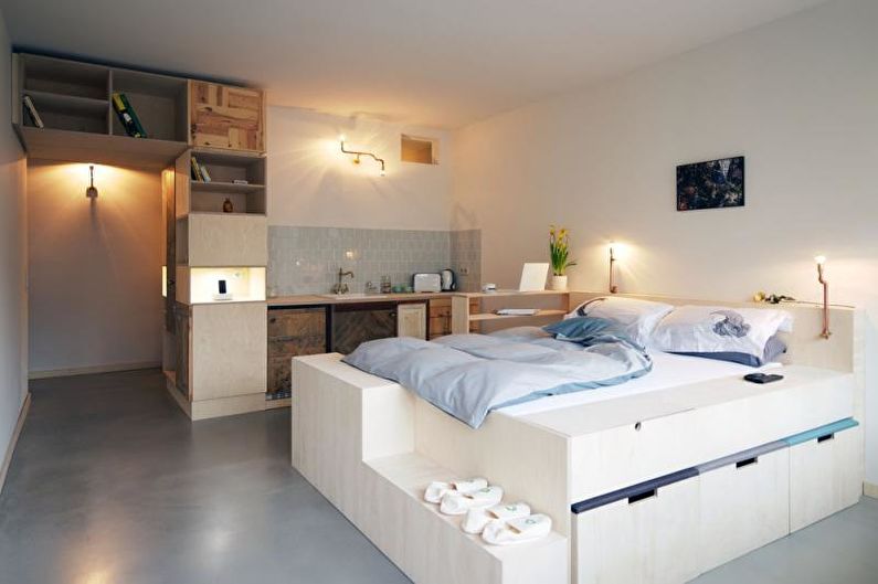 Et-værelses lejlighed design 33 kvm - En seng med en kasse i stedet for benene