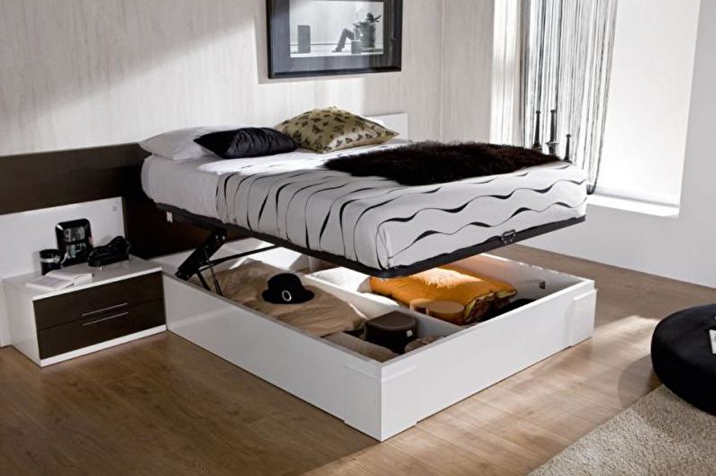 Appartement d'une pièce design 33 m² - Un lit avec une boîte au lieu de jambes